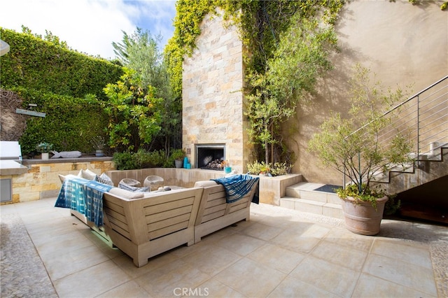 view of patio with an outdoor living space with a fireplace