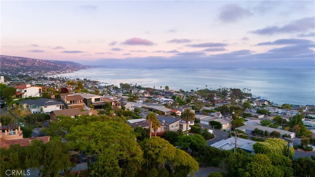 aerial view at dusk featuring a water view