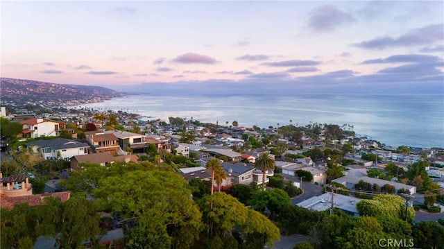 aerial view at dusk with a residential view and a water view