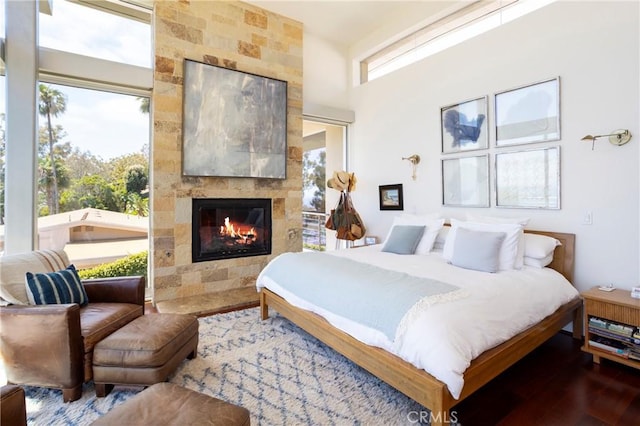 bedroom with wood finished floors and a tiled fireplace