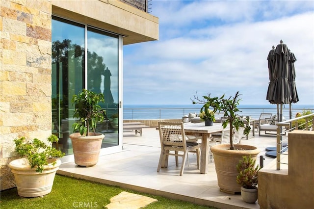 view of patio / terrace with a balcony and a water view