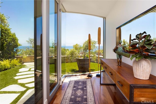 doorway to outside with wood finished floors and a wall of windows