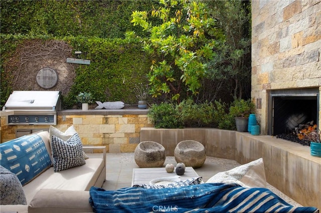 view of patio with a grill, an outdoor stone fireplace, and area for grilling