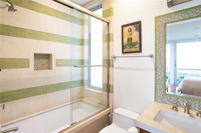 ensuite bathroom featuring plenty of natural light, backsplash, toilet, and vanity