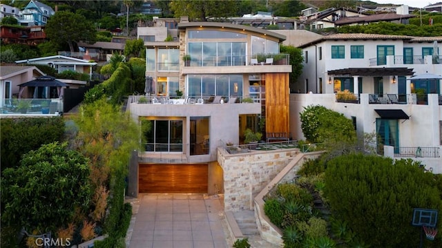 back of house featuring driveway, stucco siding, and an attached garage