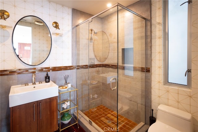 bathroom featuring tile walls, toilet, vanity, and walk in shower