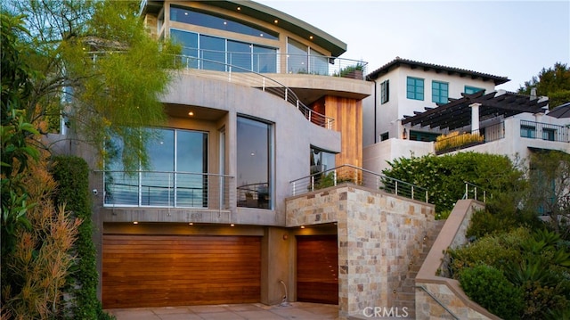 rear view of property with a balcony and a garage