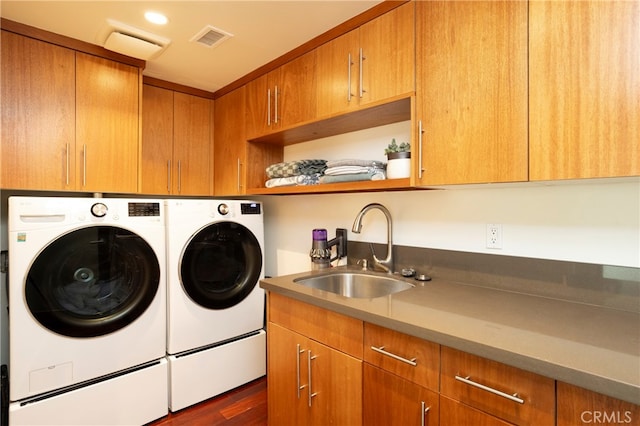 laundry area featuring sink, cabinets, washing machine and dryer, and dark wood-type flooring