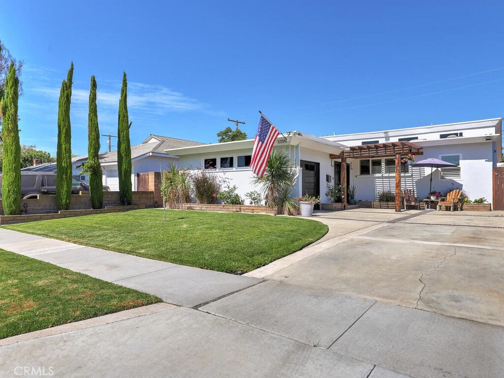 ranch-style home with a front yard and a pergola