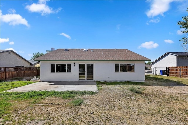 back of house with a yard and a patio