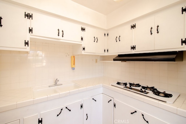 kitchen with white cabinetry, tile countertops, and tasteful backsplash