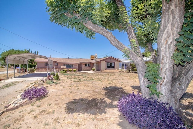ranch-style home with a detached carport and a chimney