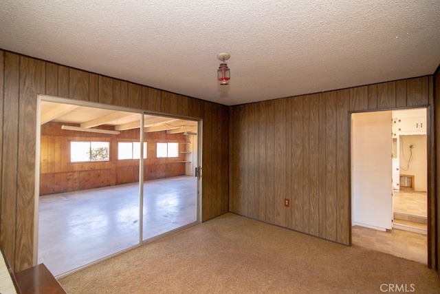 unfurnished bedroom featuring a textured ceiling, a closet, and wooden walls