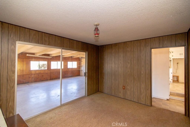 unfurnished bedroom with wood walls, a closet, and a textured ceiling