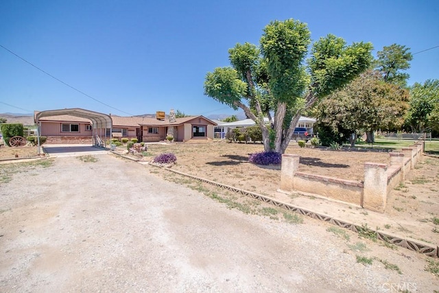 view of front of house with a carport and dirt driveway