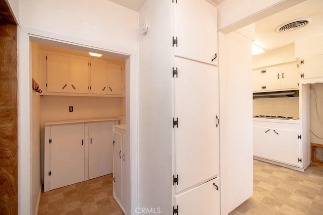hallway with visible vents and light floors