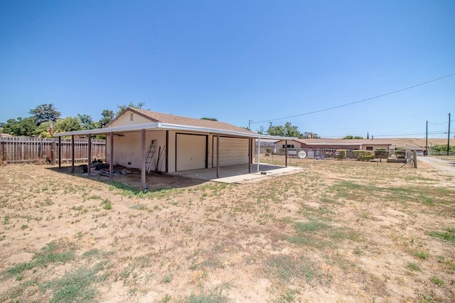view of yard featuring a detached garage, fence, and an outdoor structure