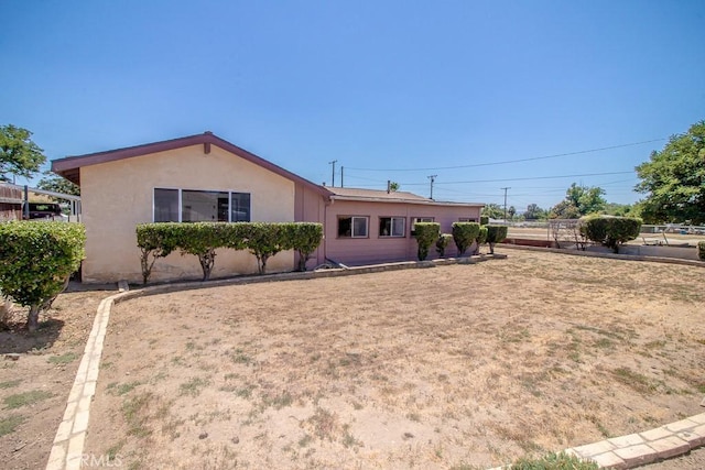 view of front of property featuring stucco siding and fence