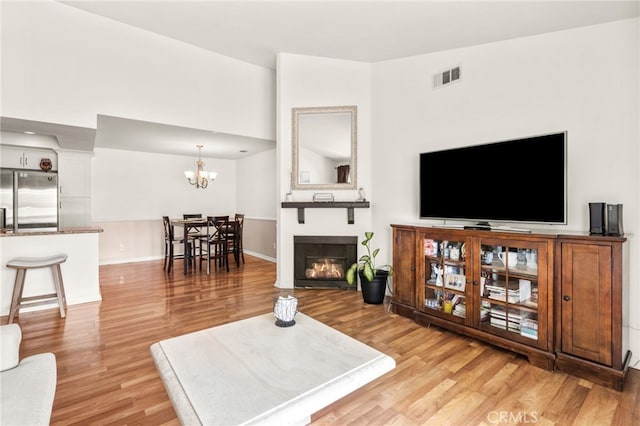 living room with a notable chandelier and light wood-type flooring