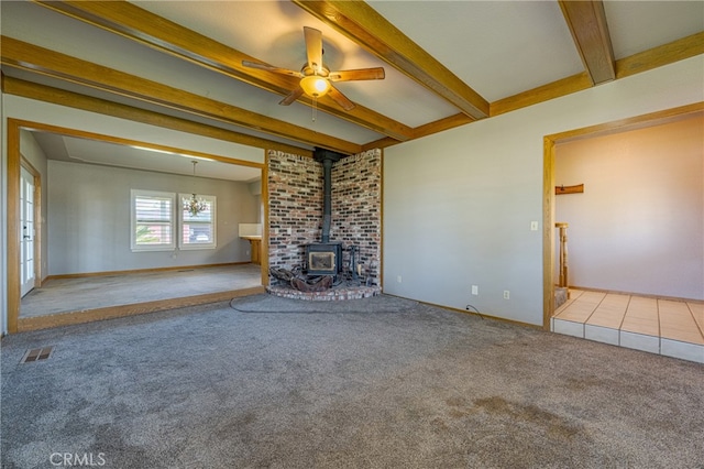 unfurnished living room with carpet, ceiling fan, and a wood stove