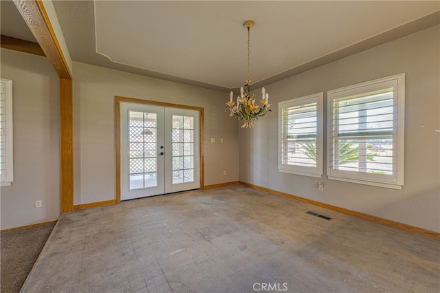 unfurnished room with light carpet, an inviting chandelier, and french doors