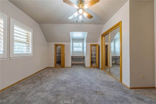 unfurnished bedroom with ceiling fan, lofted ceiling, carpet flooring, and multiple windows