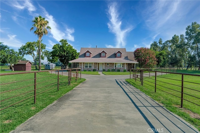 view of front facade featuring a front yard and a rural view