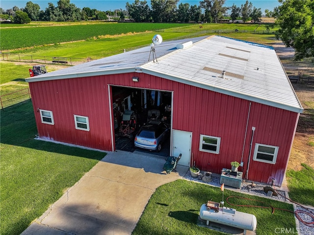 view of outdoor structure with a rural view and a yard