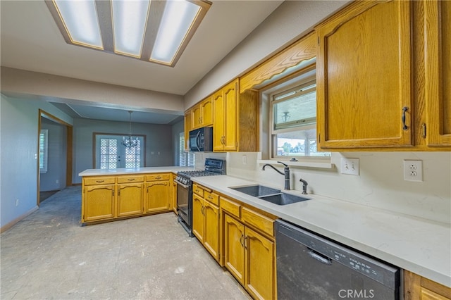 kitchen with black appliances, kitchen peninsula, decorative light fixtures, and sink