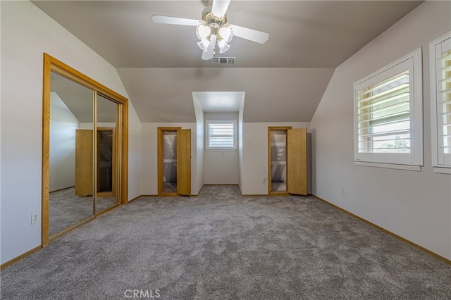 unfurnished bedroom featuring a closet, vaulted ceiling, ceiling fan, and carpet flooring