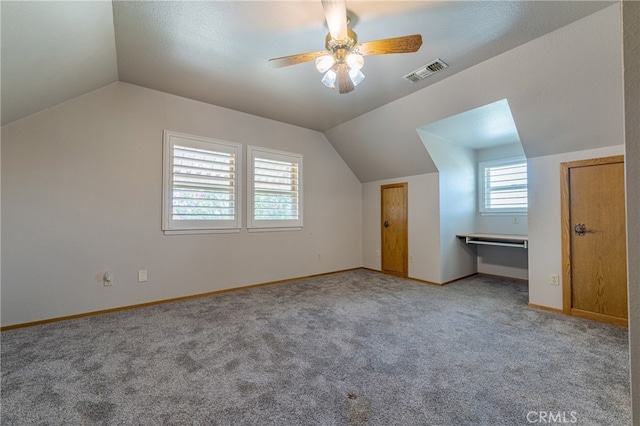 additional living space with light carpet, vaulted ceiling, and ceiling fan