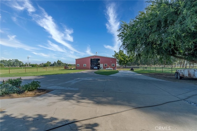 exterior space with a front yard, a rural view, and an outbuilding