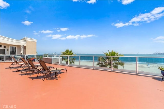 view of patio with a water view and a balcony