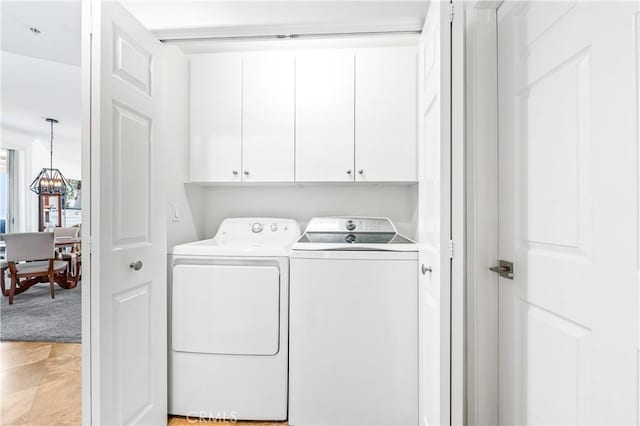 clothes washing area with cabinet space and washing machine and dryer