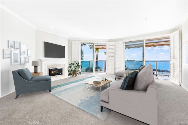 living room with baseboards, a glass covered fireplace, crown molding, and light colored carpet