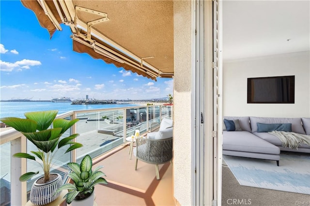 balcony featuring a water view and an outdoor living space