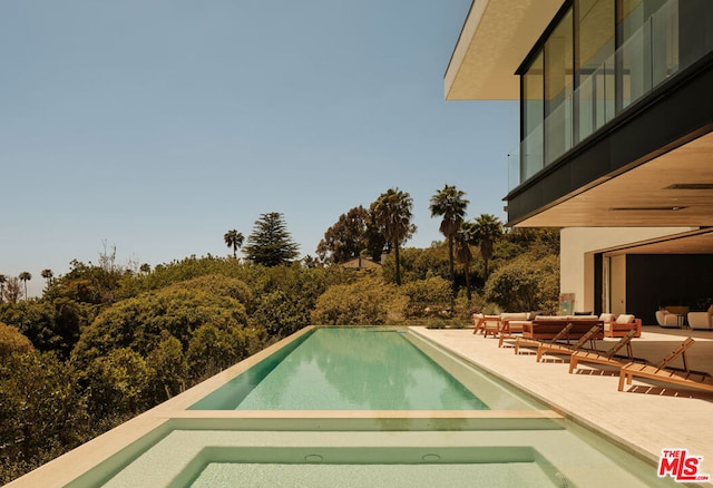 view of pool with an outdoor living space and a patio