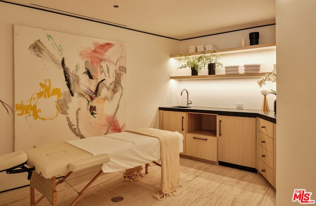 bedroom with light wood-type flooring and sink