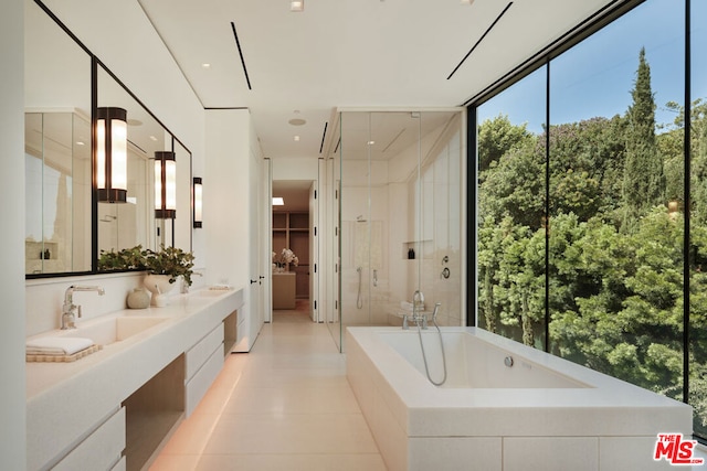 bathroom with tile patterned floors, independent shower and bath, and vanity