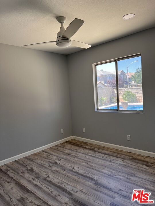 spare room featuring ceiling fan and hardwood / wood-style floors