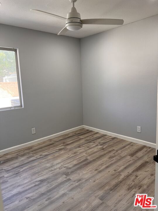 unfurnished room with wood-type flooring and ceiling fan