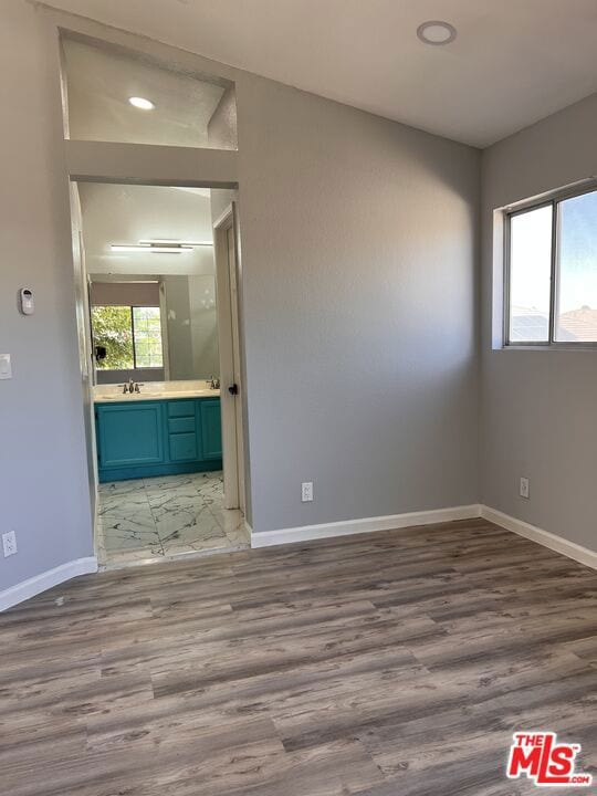 unfurnished room featuring sink and light hardwood / wood-style flooring