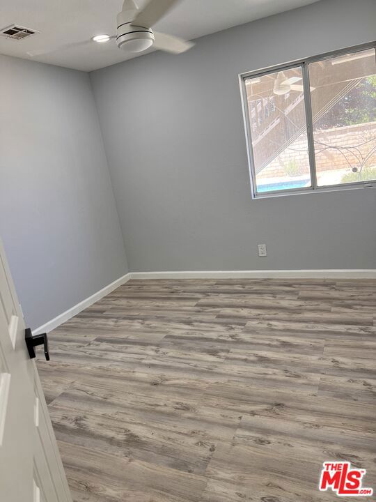 empty room featuring ceiling fan and light wood-type flooring