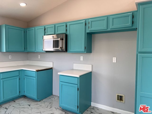 kitchen featuring blue cabinetry and lofted ceiling