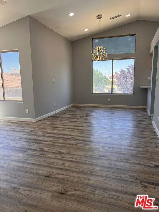 unfurnished dining area with lofted ceiling and dark hardwood / wood-style floors