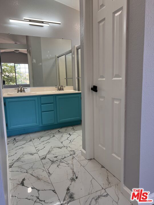 bathroom featuring vanity and a shower with door