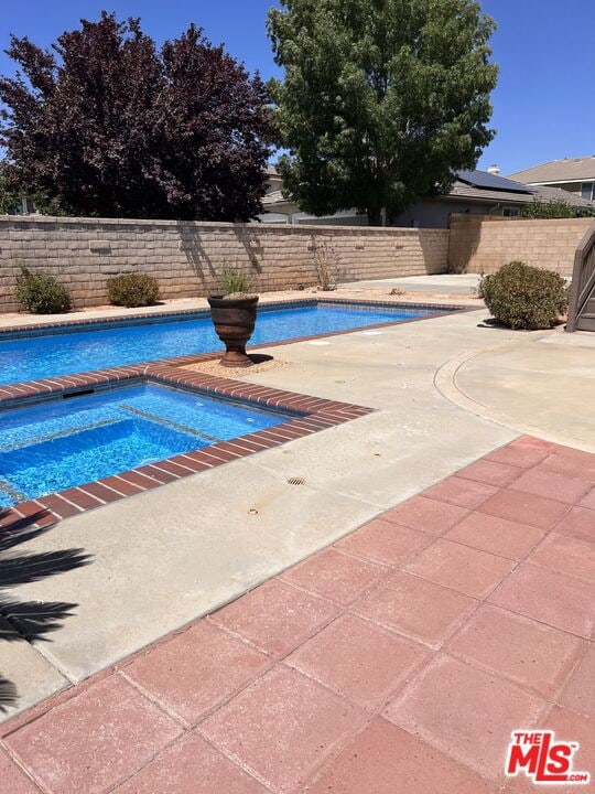 view of pool with an in ground hot tub and a patio