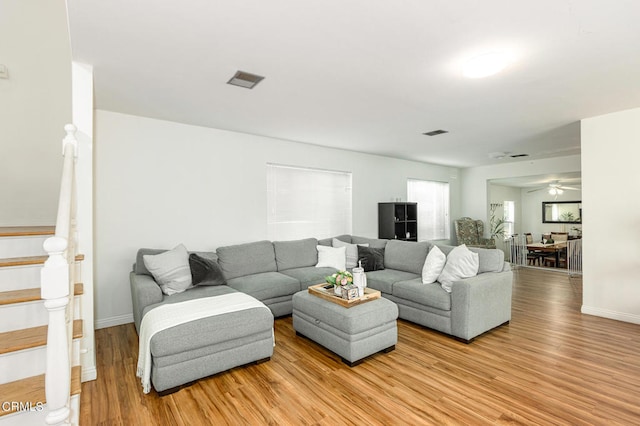 living room with ceiling fan and light hardwood / wood-style flooring