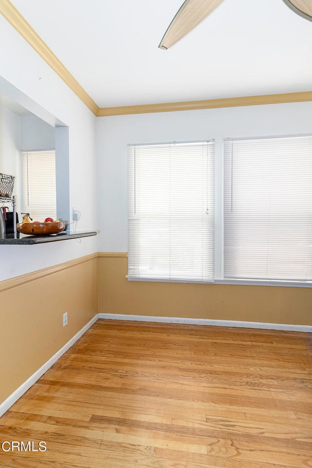 empty room with light hardwood / wood-style floors and ornamental molding