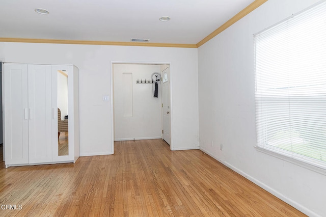 empty room featuring ornamental molding and light wood-type flooring